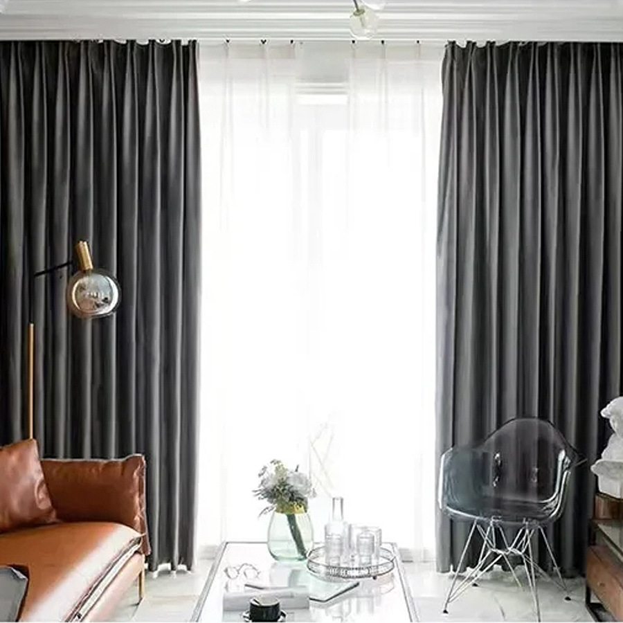 Rideaux gris dans un salon style rétro moderne avec un canapé en cuir marron et une chaise transparente.