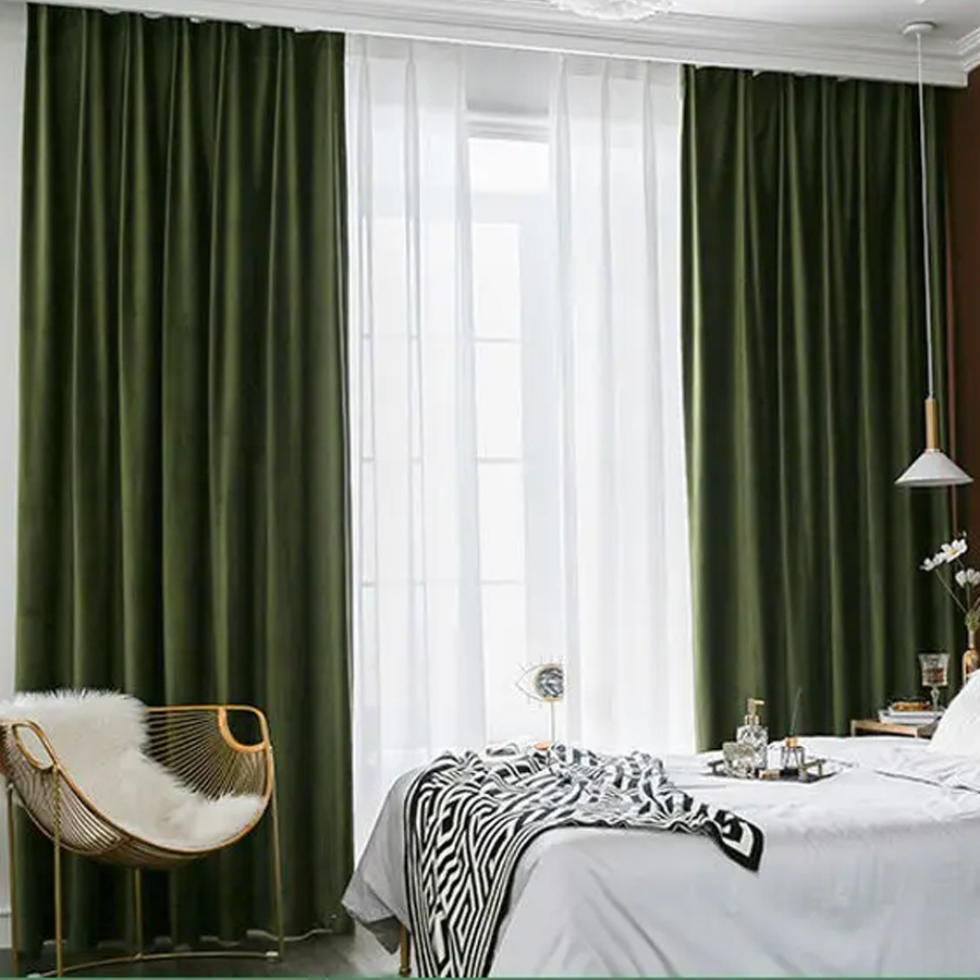Rideaux vert olive dans une chambre avec un lit blanc avec avec un plaid zébré et une chaise.